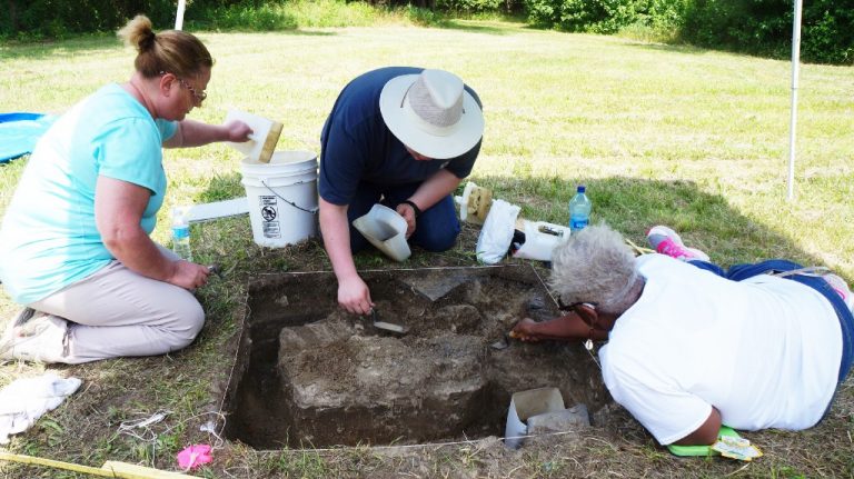 Ph.D candidate and volunteers dig for artifacts at the site where Dr.