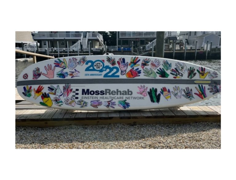 MossRehab representatives thank Carusi Middle School students for surfboard donation